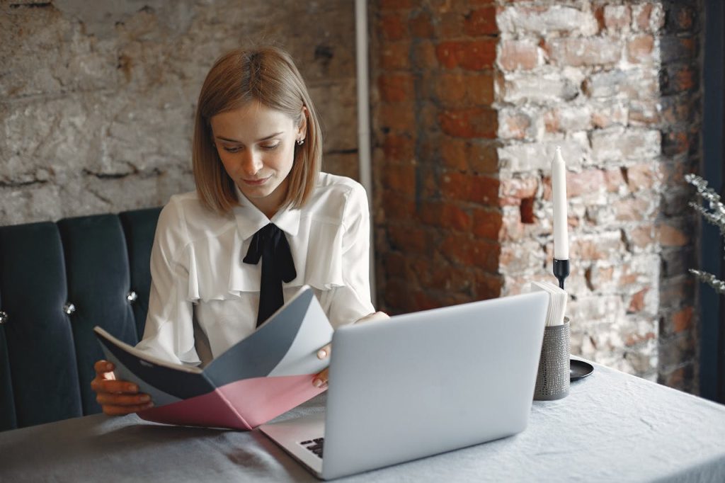 focused-businesswoman-reading-notes-in-planner-in-cafe-4173258 Concentrated businesswoman in elegant formal outfit sitting at cafe table and reading notes in planner while working on laptop